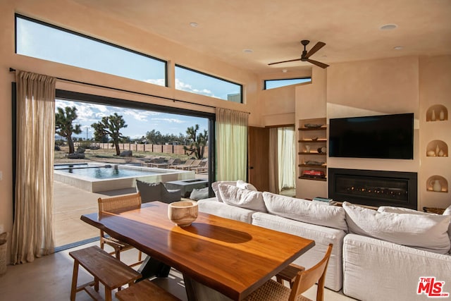 interior space featuring ceiling fan, high vaulted ceiling, and plenty of natural light