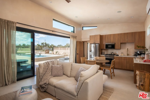 living room with high vaulted ceiling, a healthy amount of sunlight, and sink