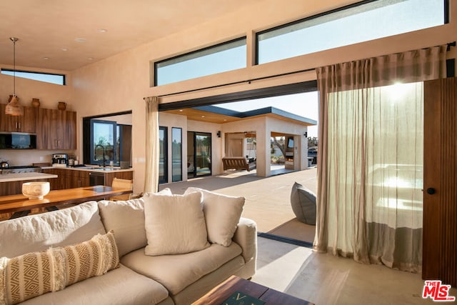 living room featuring a towering ceiling, sink, and plenty of natural light