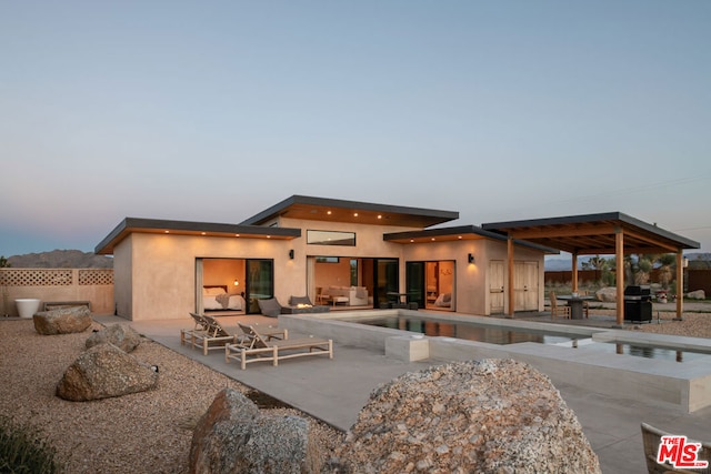 back house at dusk with a patio