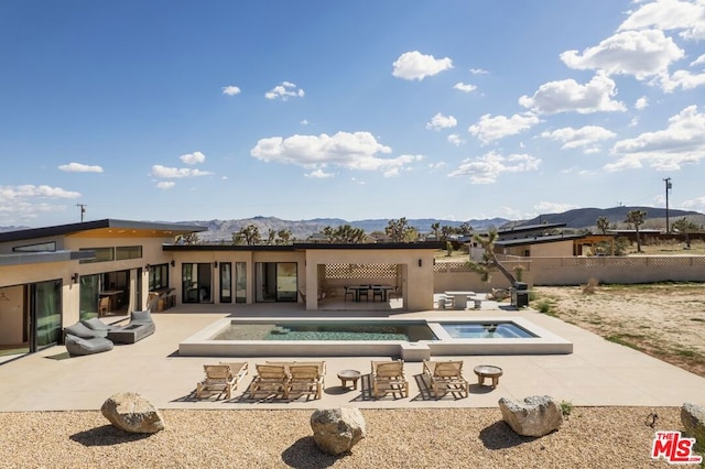 view of swimming pool featuring an in ground hot tub, a patio, and a mountain view