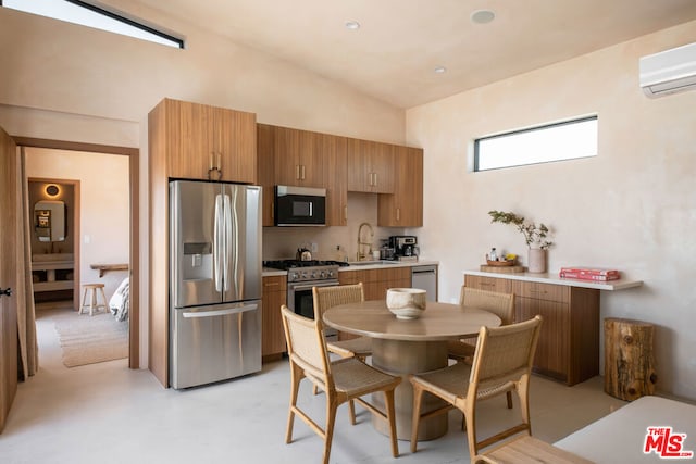 kitchen featuring sink, stainless steel appliances, vaulted ceiling, and a wall unit AC