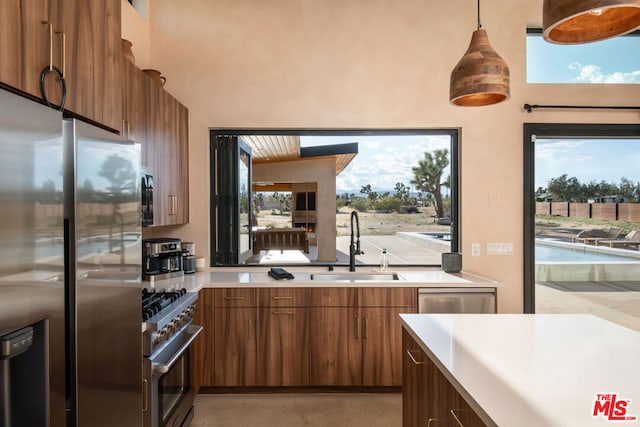 kitchen with sink, pendant lighting, stainless steel appliances, and plenty of natural light