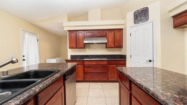 kitchen with appliances with stainless steel finishes, sink, vaulted ceiling, dark stone countertops, and light tile patterned floors