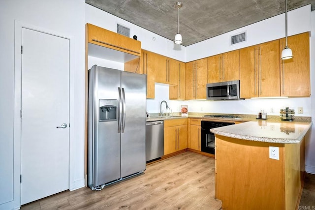 kitchen featuring kitchen peninsula, hanging light fixtures, appliances with stainless steel finishes, light hardwood / wood-style flooring, and sink