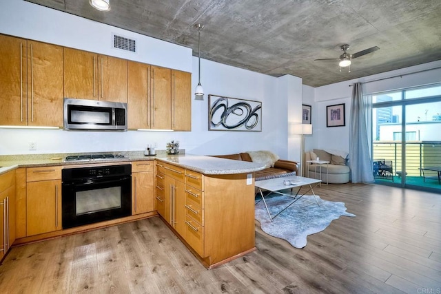 kitchen with light hardwood / wood-style floors, appliances with stainless steel finishes, kitchen peninsula, and ceiling fan