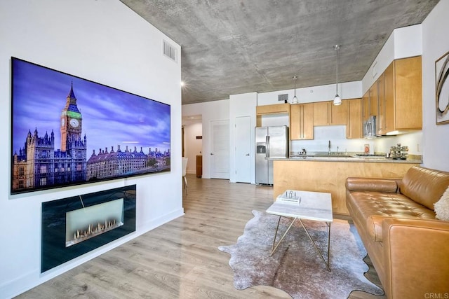 living room with sink and light wood-type flooring