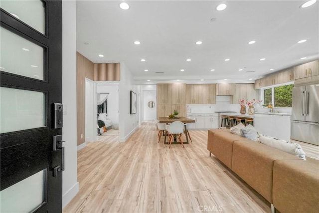 living room with light hardwood / wood-style flooring and sink