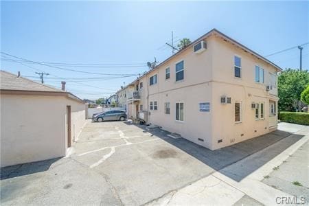 view of side of property with a wall mounted air conditioner