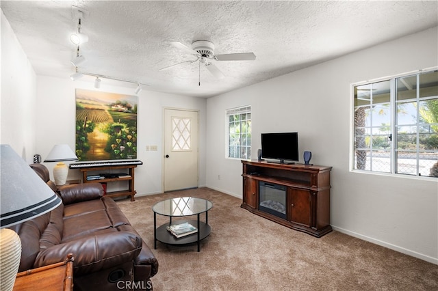 carpeted living room featuring a textured ceiling, track lighting, and ceiling fan