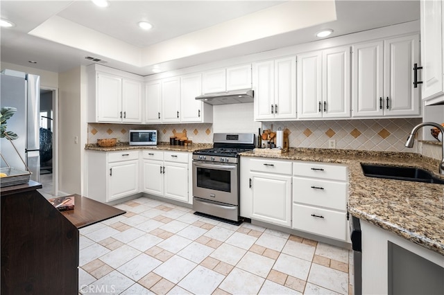 kitchen featuring backsplash, sink, appliances with stainless steel finishes, and white cabinetry