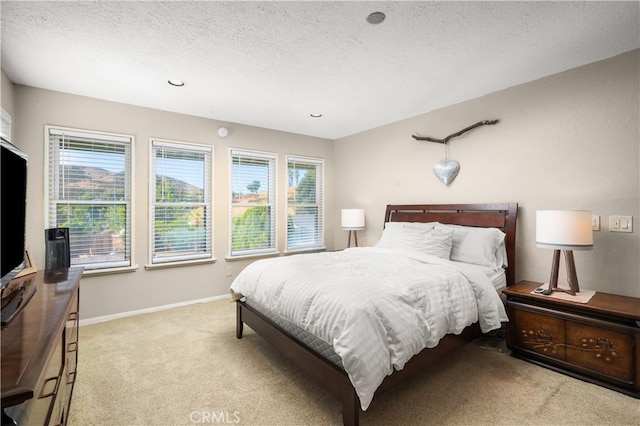 bedroom featuring a textured ceiling and light colored carpet