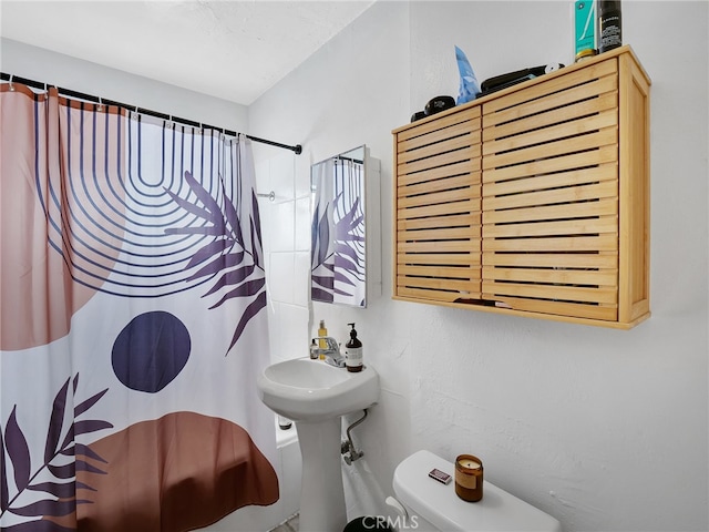 bathroom featuring a shower with shower curtain and toilet