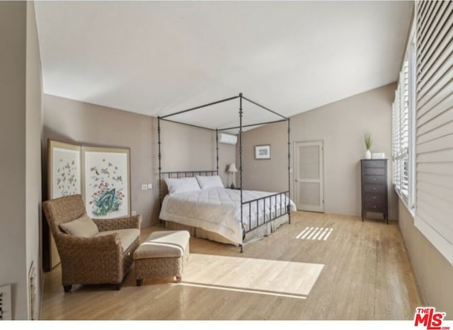 bedroom with lofted ceiling and light wood-type flooring