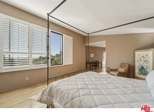 bedroom featuring light hardwood / wood-style flooring and lofted ceiling