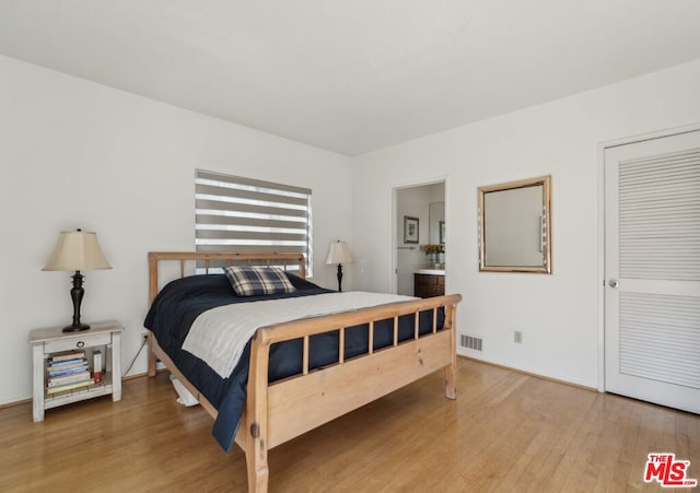 bedroom featuring hardwood / wood-style flooring and ensuite bath