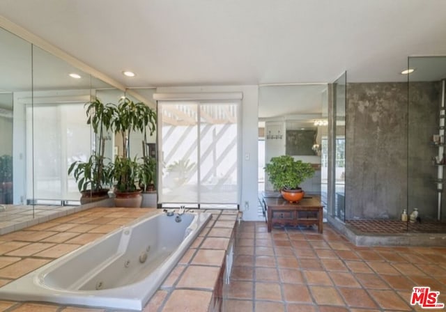 bathroom featuring tiled tub and tile patterned flooring