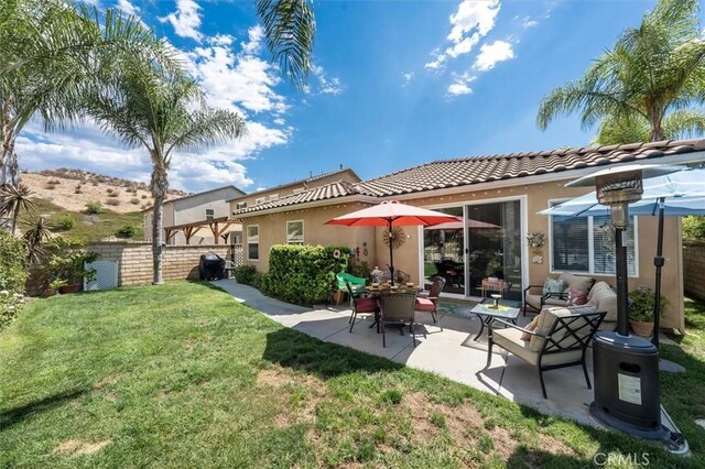 back of property with a lawn and a patio