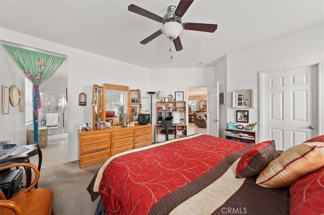 bedroom with tile patterned flooring, ensuite bathroom, and ceiling fan