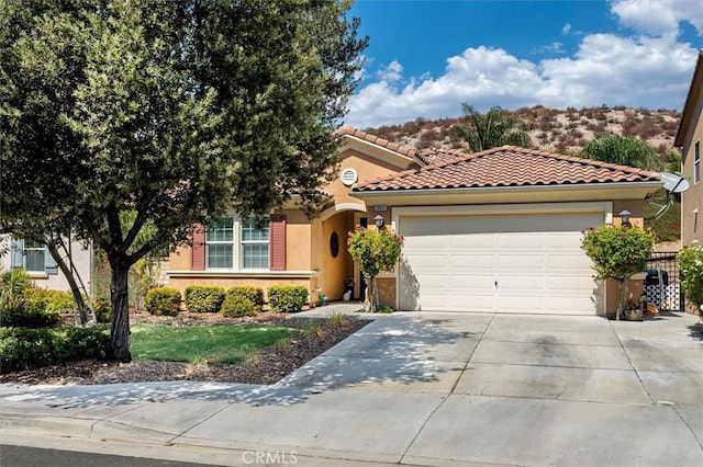 view of front of home with a garage, driveway, a tile roof, and stucco siding