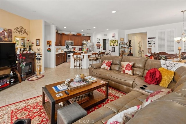 tiled living room with a notable chandelier