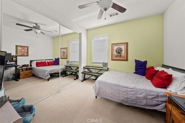 carpeted bedroom with ceiling fan and a closet