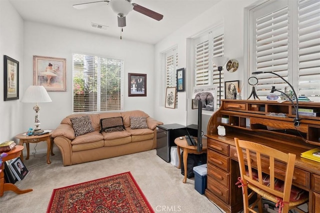 interior space with ceiling fan and light colored carpet