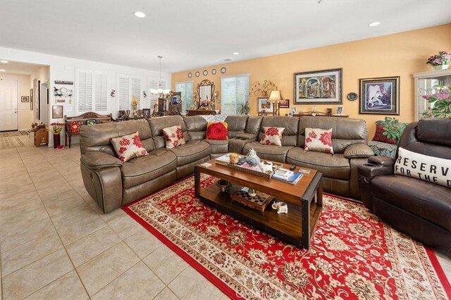 tiled living room with a notable chandelier