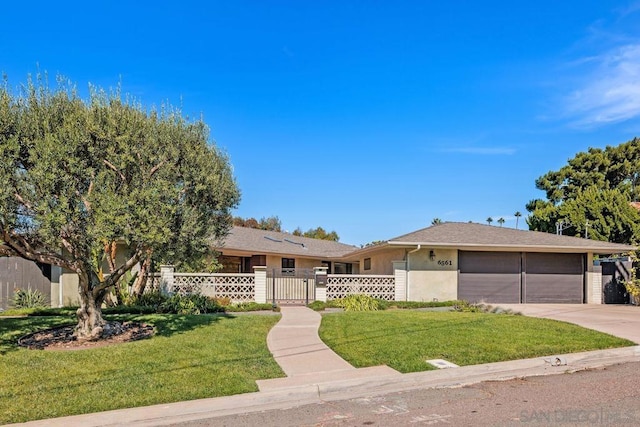 ranch-style home featuring a garage and a front lawn