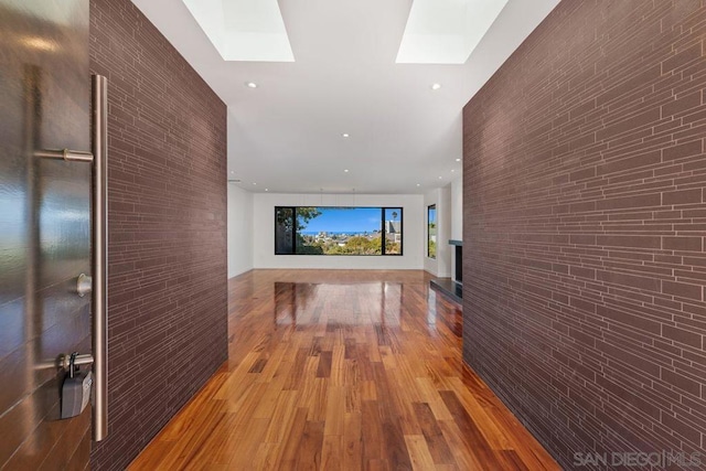 corridor featuring light hardwood / wood-style floors and a skylight