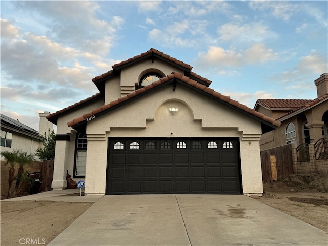 mediterranean / spanish-style home with a garage