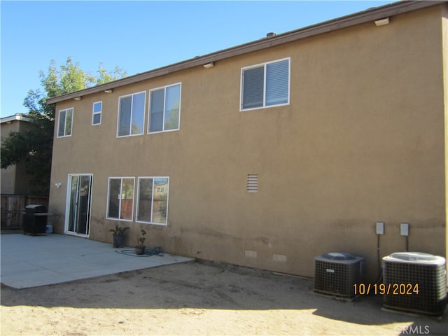 back of property with cooling unit and a patio