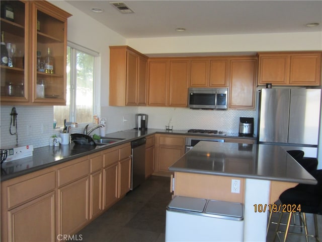 kitchen featuring tasteful backsplash, stainless steel appliances, sink, and a kitchen island