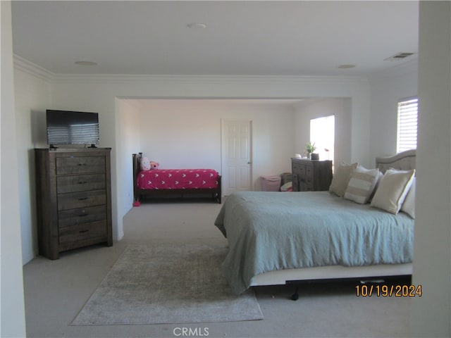 carpeted bedroom with ornamental molding