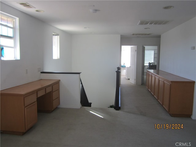 interior space featuring light colored carpet and built in desk