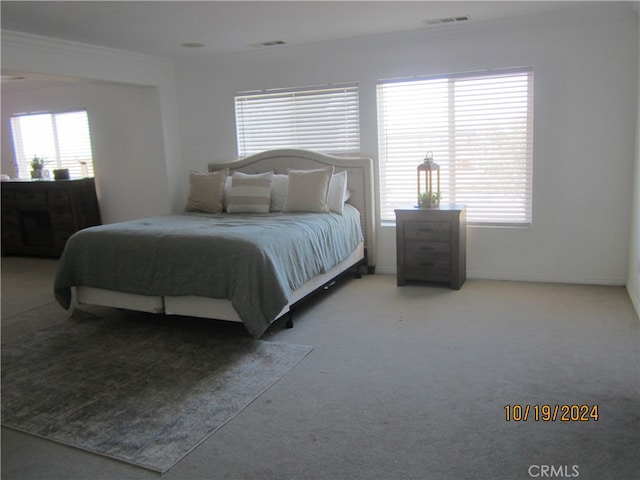 bedroom featuring ornamental molding and carpet