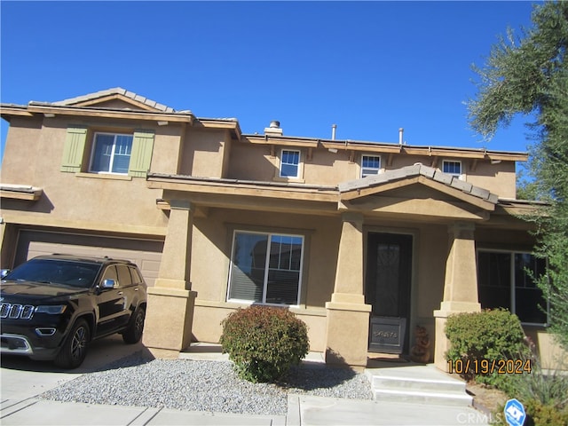 view of front of property featuring covered porch and a garage