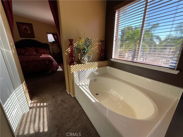 bathroom featuring a washtub and vaulted ceiling