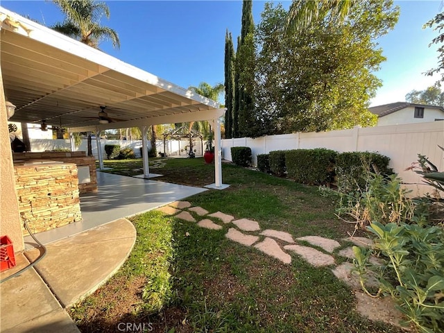 view of yard with ceiling fan and a patio