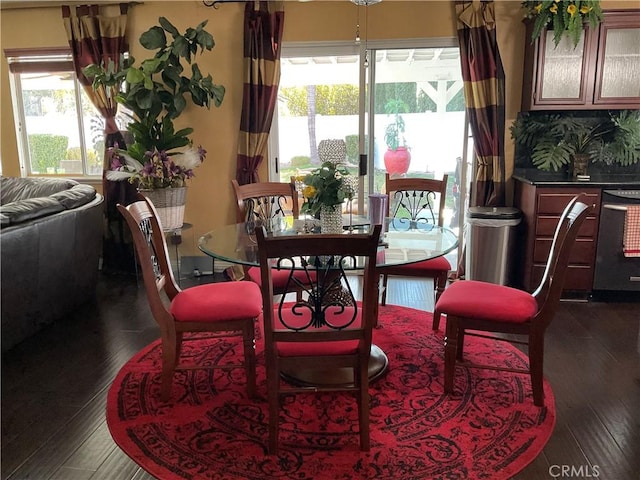 dining area with dark wood-type flooring and a healthy amount of sunlight