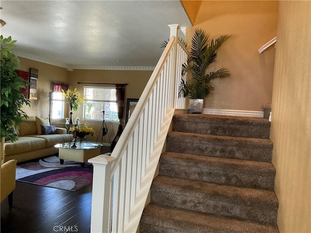 stairs with decorative columns and hardwood / wood-style floors