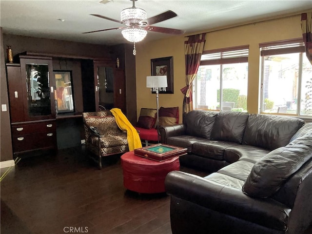 living room with ceiling fan and dark wood-type flooring