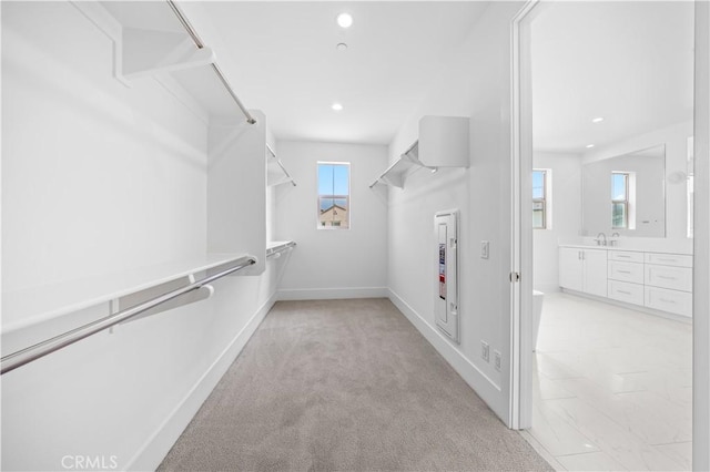 spacious closet featuring light carpet and sink