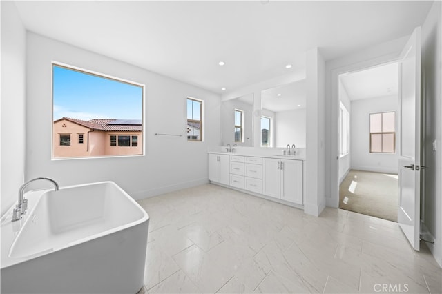 bathroom with vanity, a tub to relax in, and a wealth of natural light