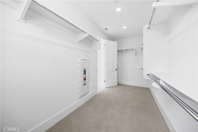 walk in closet featuring light colored carpet