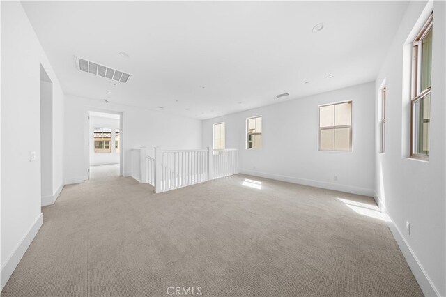 unfurnished room featuring light carpet