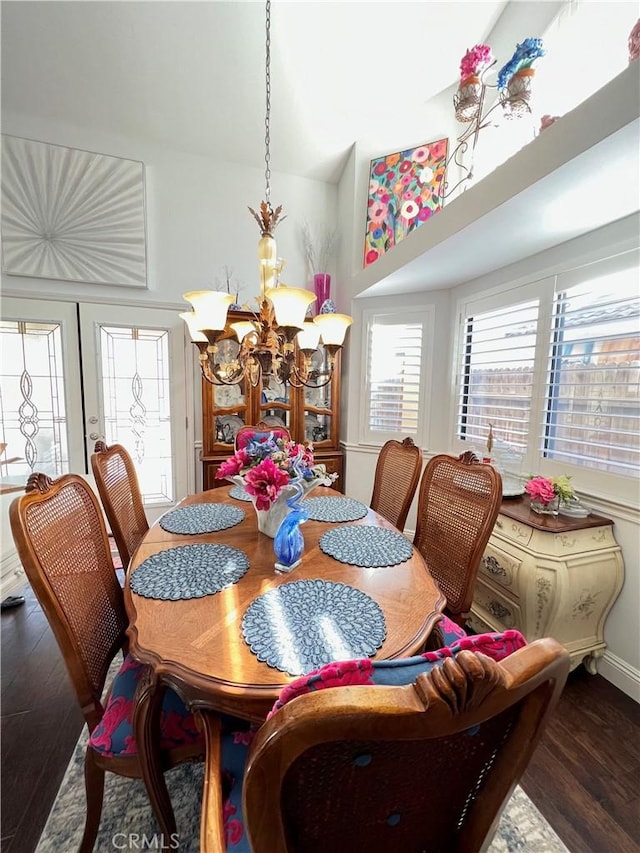 dining room featuring french doors, dark wood-type flooring, and a notable chandelier