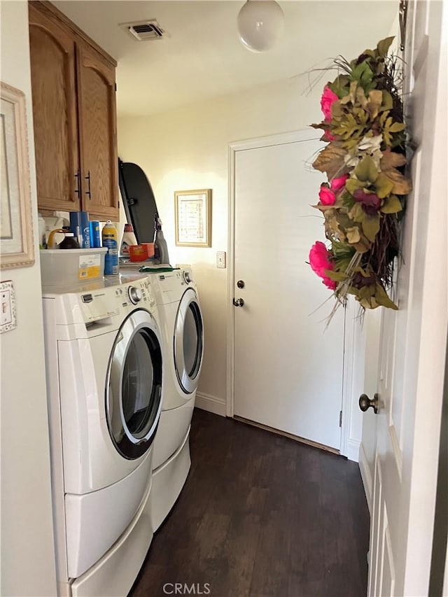 laundry room with dark hardwood / wood-style flooring, cabinets, and independent washer and dryer