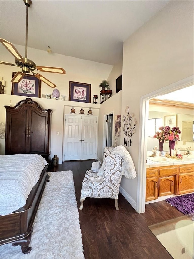 bedroom featuring dark hardwood / wood-style floors, ceiling fan, ensuite bathroom, and high vaulted ceiling