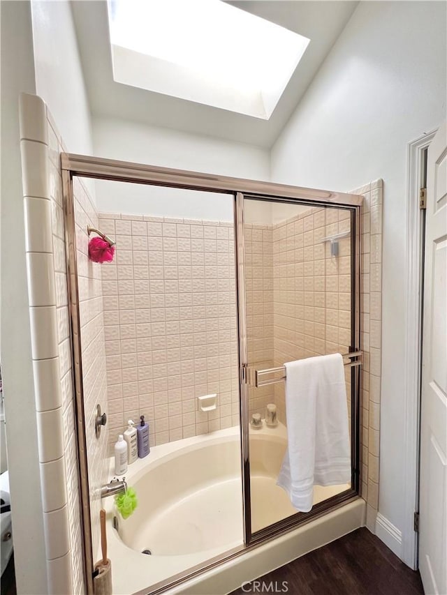 bathroom with hardwood / wood-style floors and a skylight